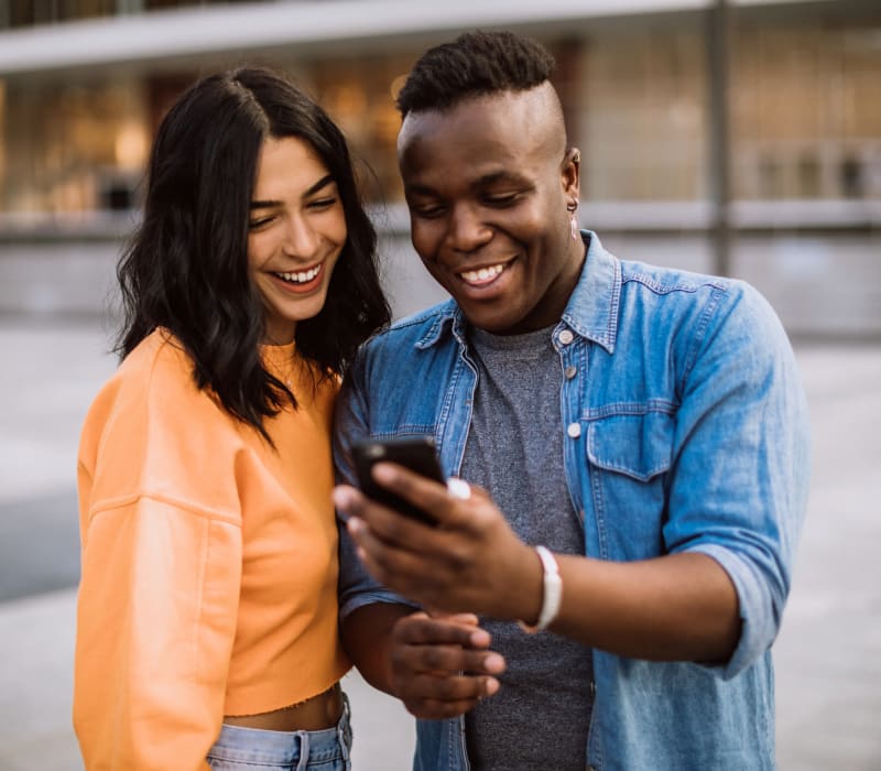 Residents looking together on smart phone near The Villagio in Northridge, California