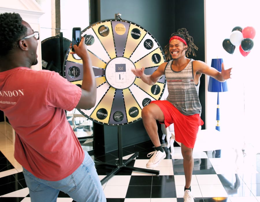 Residents playing a wheel spin game at an event at The London, a Campus Life & Style Autograph Collection community