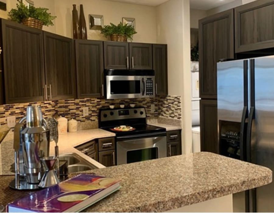 Apartment kitchen with stainless steel appliances at The Margot on Sage in Houston, Texas