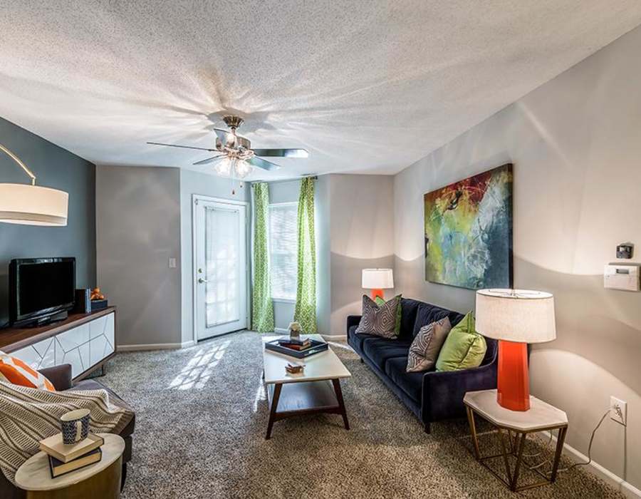 Model apartment living room with a ceiling fan at Acasă Willowbrook Apartments in Simpsonville, South Carolina