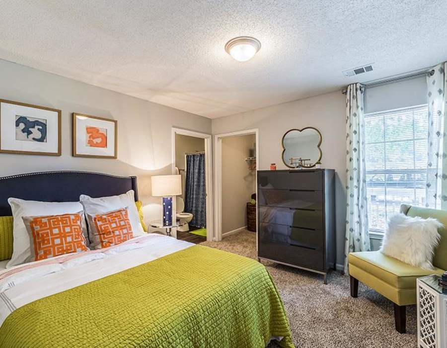 Model apartment bedroom with a walk in closet at Acasă Willowbrook Apartments in Simpsonville, South Carolina