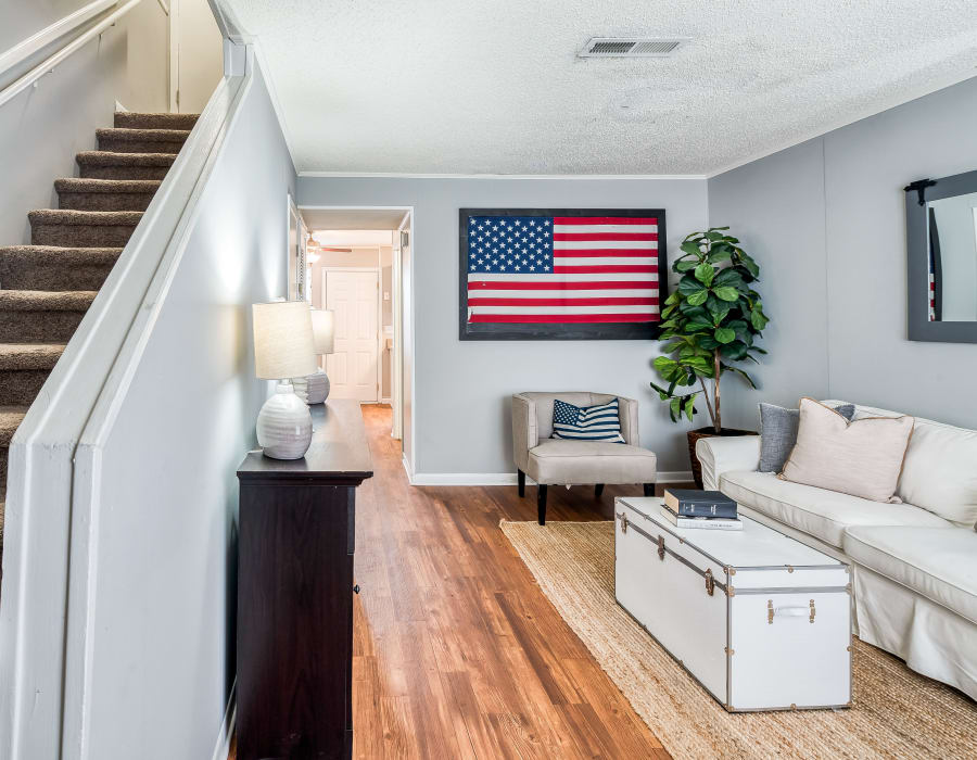 Model apartment with hardwood floors and an american flag on the wall at Patriot's Place Townhomes in Goose Creek, South Carolina
