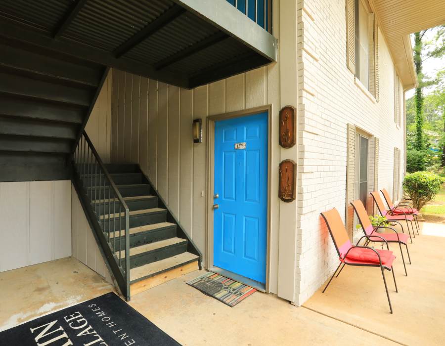 first floor apartment doorway with chairs outside at Britain Village in Lawrenceville, Georgia