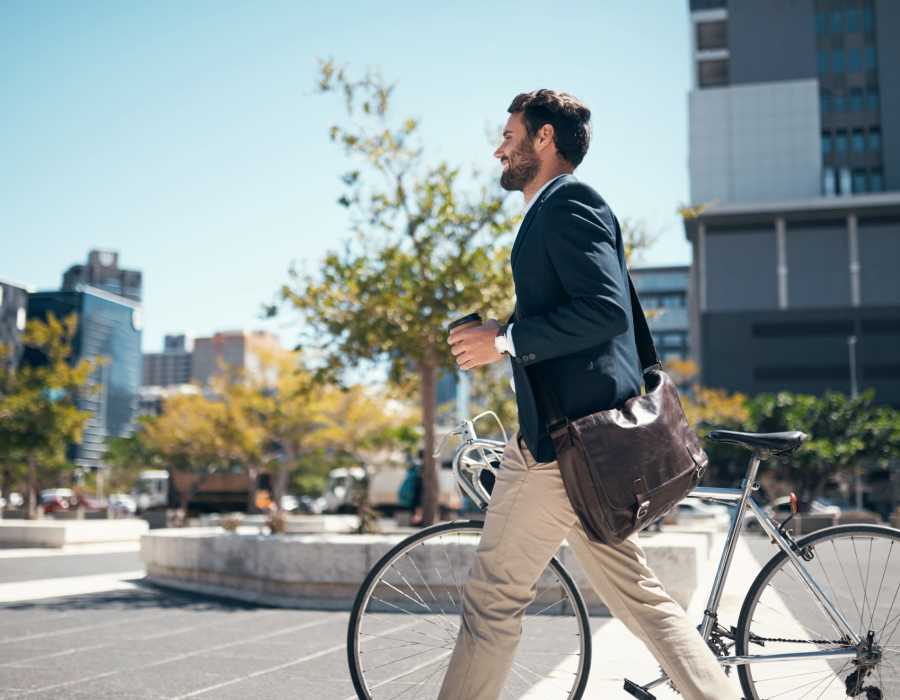 Man walking with his bicycle and coffee