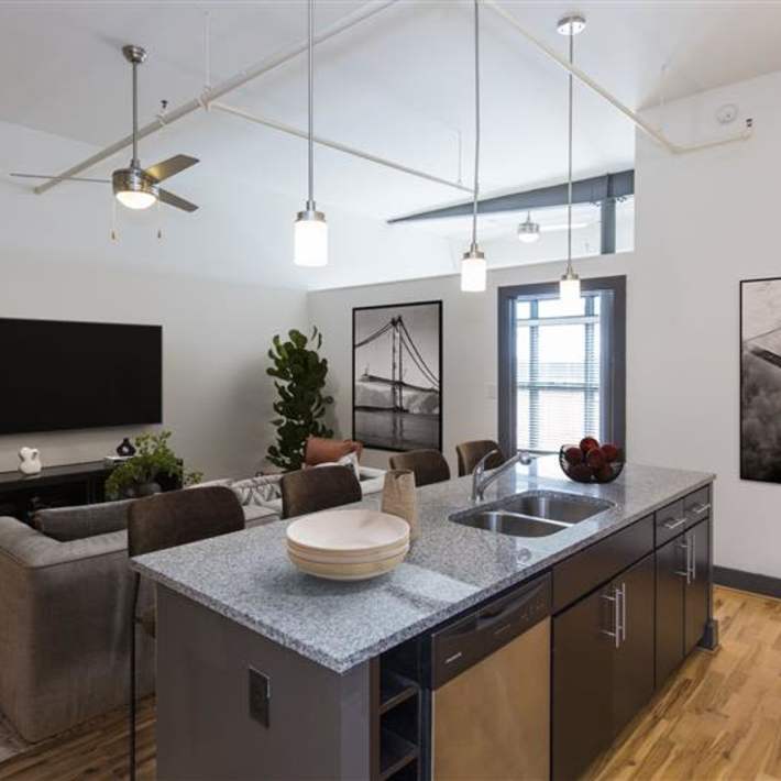 Open-concept kitchen with granite island and stainless steel sink at Scotts Edge in Richmond, Virginia