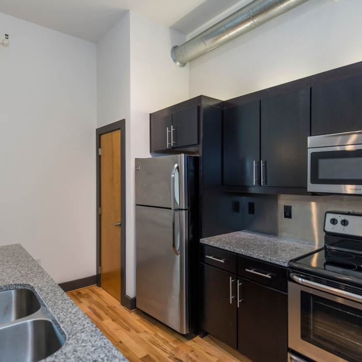 Modern kitchen with stainless steel appliances and dark cabinetry at Scotts Edge in Richmond, Virginia