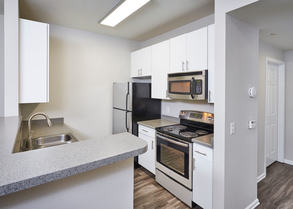 new white renovation cabinetry with stainless steel appliances at Bear Valley Park in Denver, Colorado