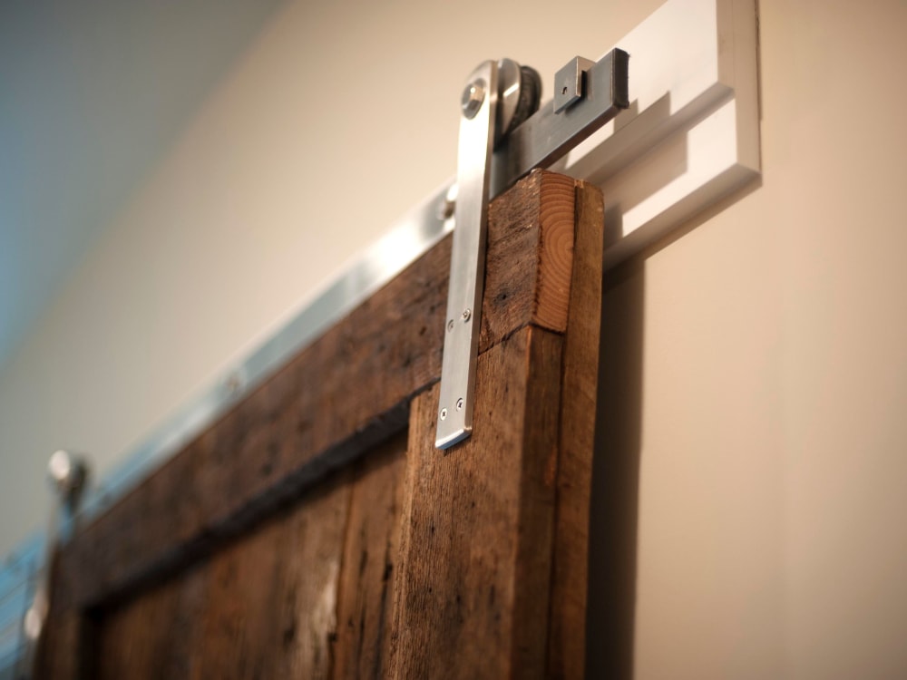 Sliding bedroom door made from reclaimed barn wood in a model home at Brooklyn Yard in Portland, Oregon