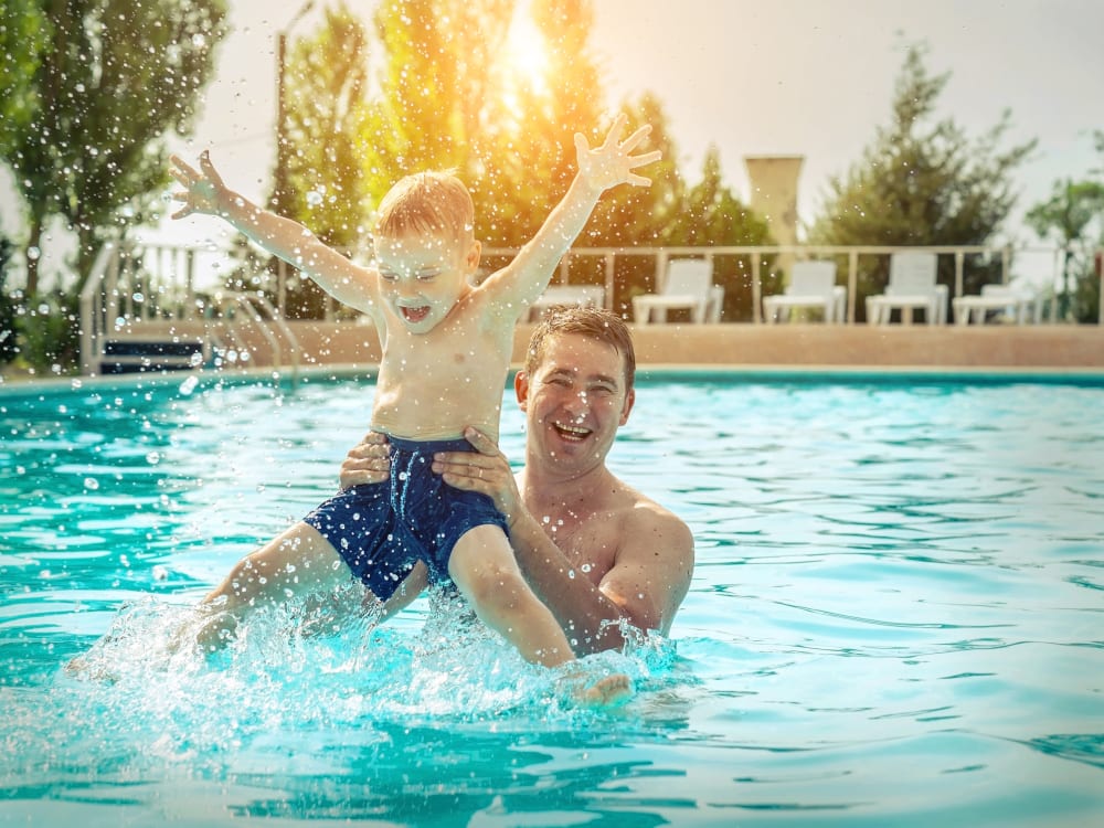 Father and his kid in the pool at TerraLane on Cotton in Surprise, Arizona