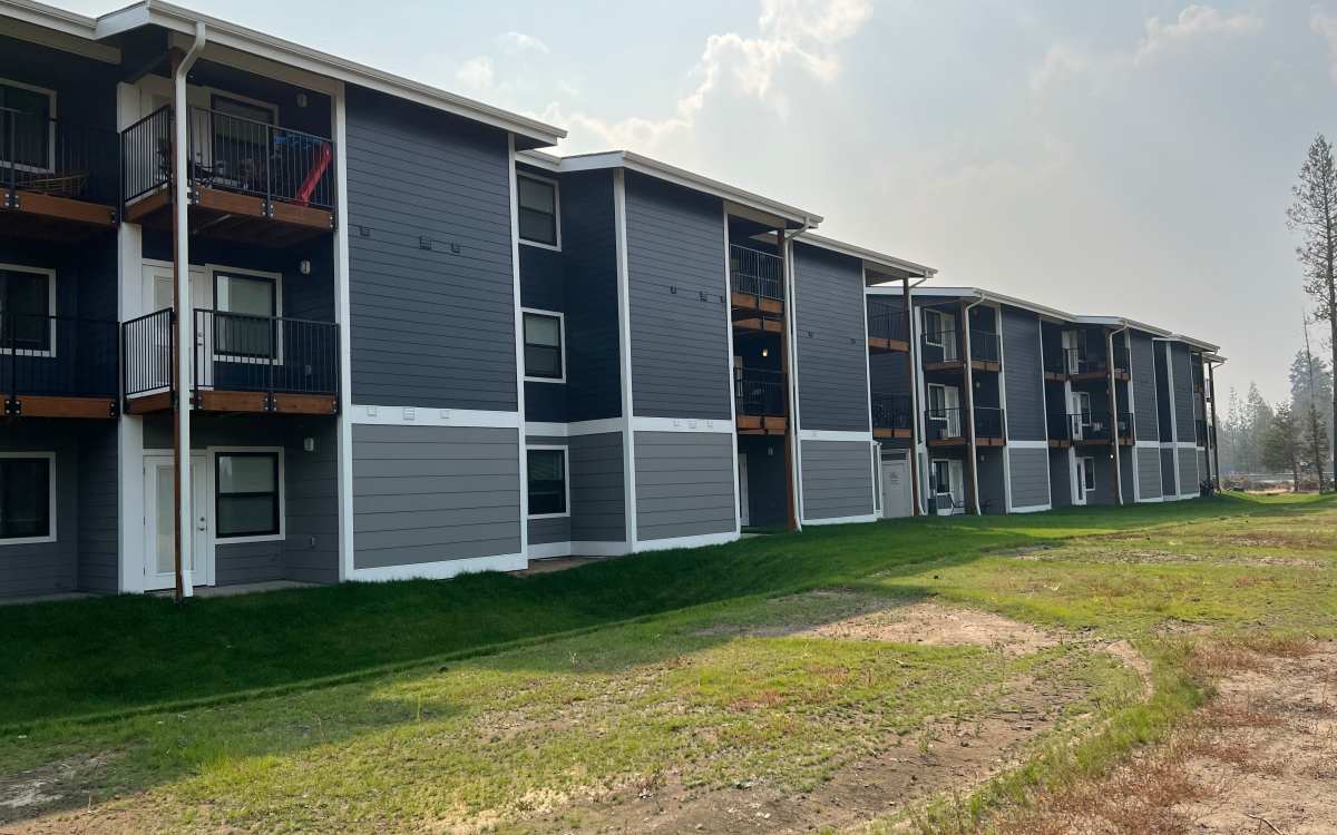 View of apartment building with well-maintained lush lawn at Pine View in La Pine, Oregon
