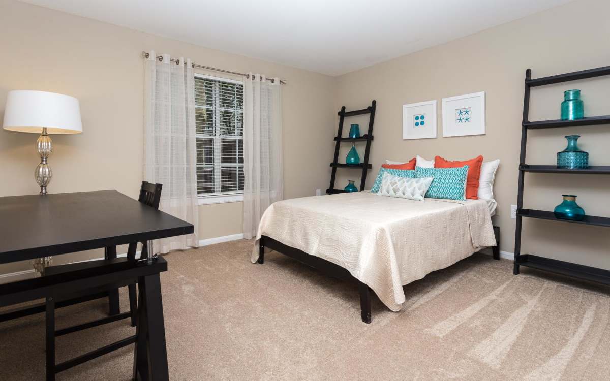 Spacious bedroom with a comfortable bed, and a table at Beacon Place at Kentlands in Gaithersburg, Maryland