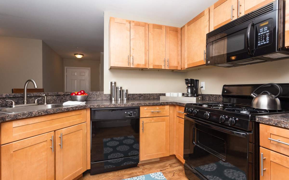 Kitchen with wooden cabinets, stainless-steel appliances at Beacon Place at Kentlands in Gaithersburg, Maryland