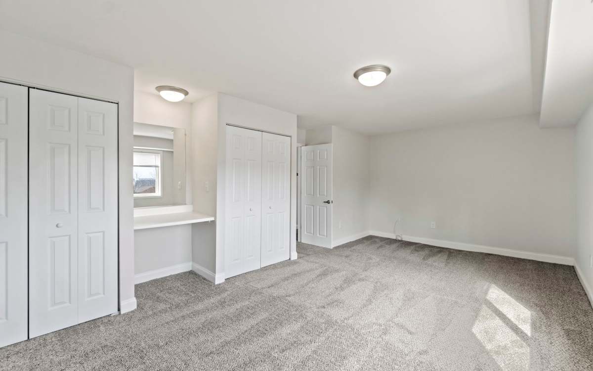Bedroom with large closets and working table at Chesapeake Landing Apartments in Landover Hills, Maryland