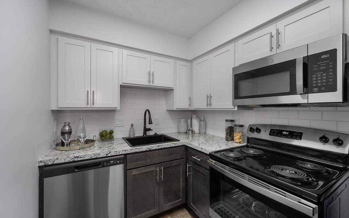 Renovated kitchen with two-toned cabinets and stainless appliances at Millcroft Apartments & Townhomes in Milford, Ohio