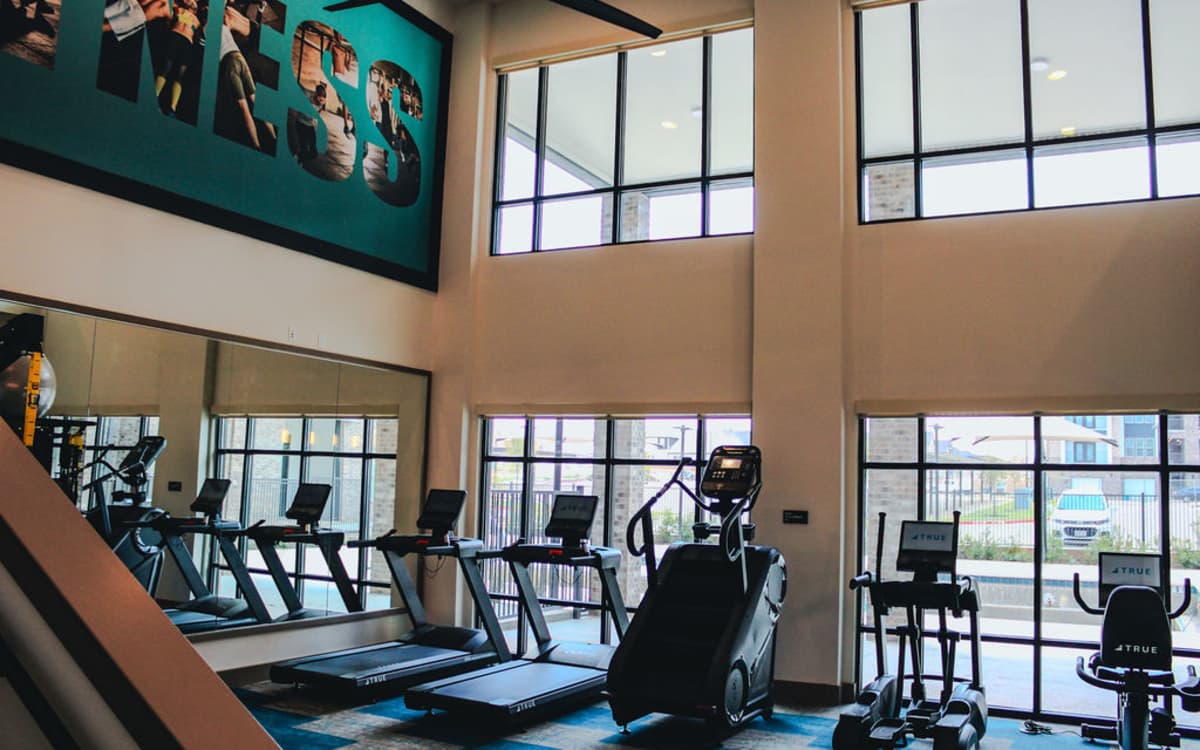 Couple of resident women working out together in the community fitness center at The Heyward Apartments in Corinth, Texas