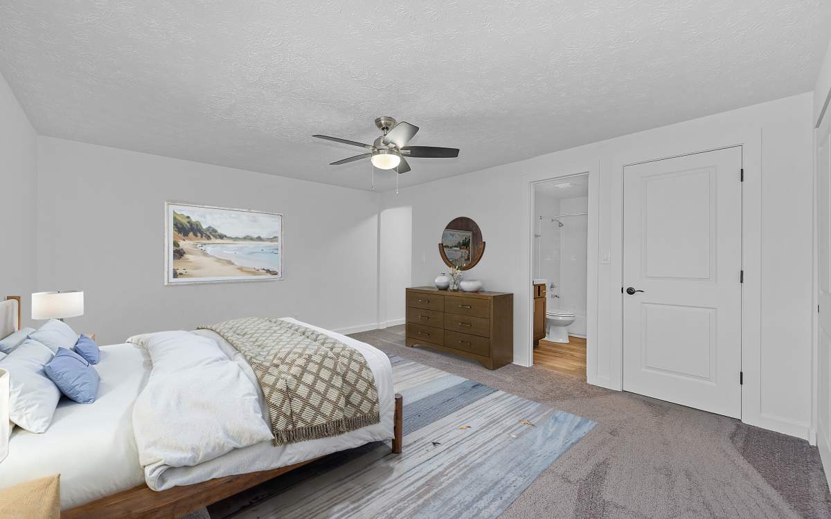 Bedroom with wall to wall carpeting at Millcroft Apartments & Townhomes in Milford, Ohio