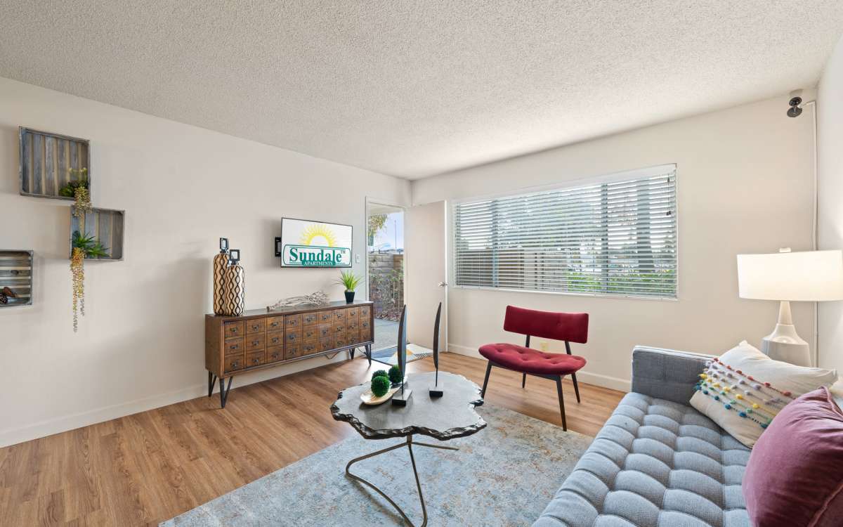 Spacious living room with wood-style flooring at Sundale Apartments in Fremont, California