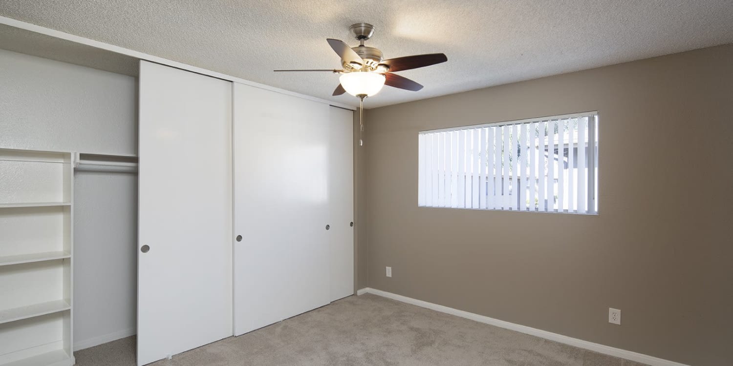 Bedroom with a ceiling fan at Country Apartments in Chula Vista, California
