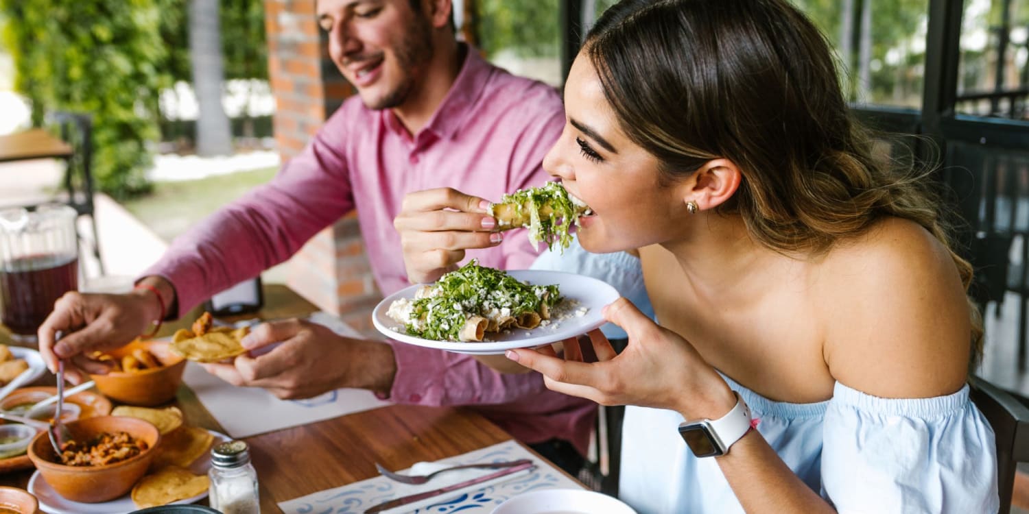 Happy couple eating in restaurant near Sierra Gardens in Riverside, California