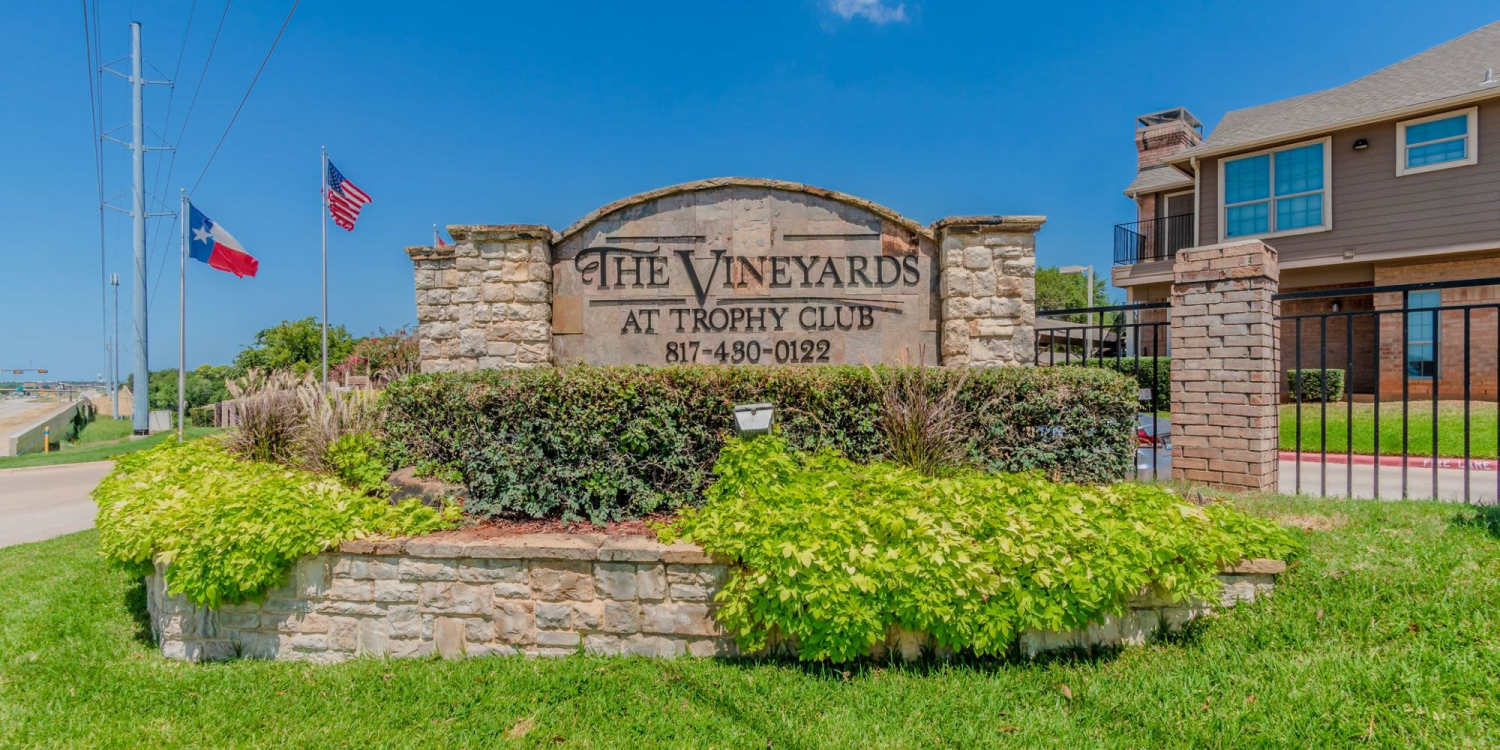 Community sign board with green lawn at The Vineyards at Trophy Club in Trophy Club, Texas