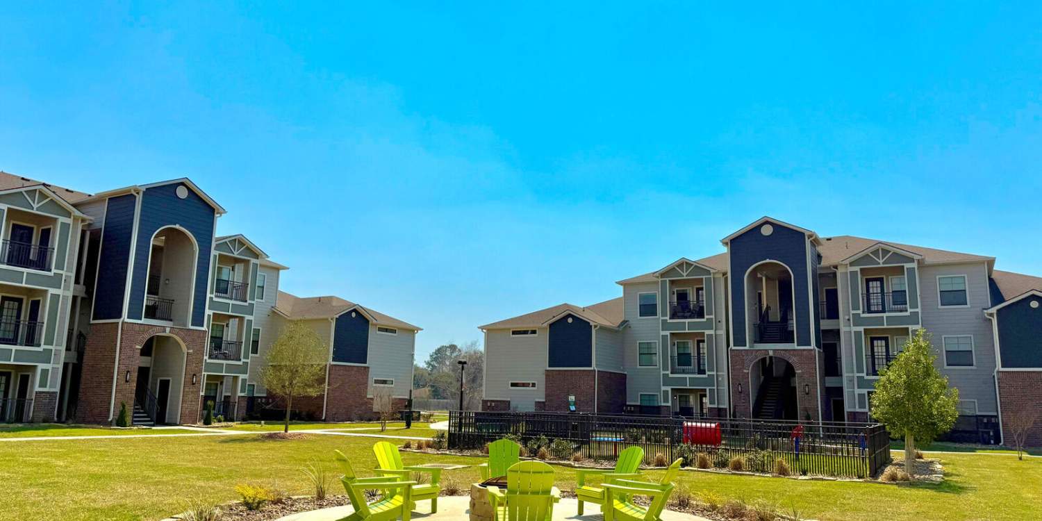 Exterior view of the community with fireplace and green lawn at The Colony in Victoria, Texas