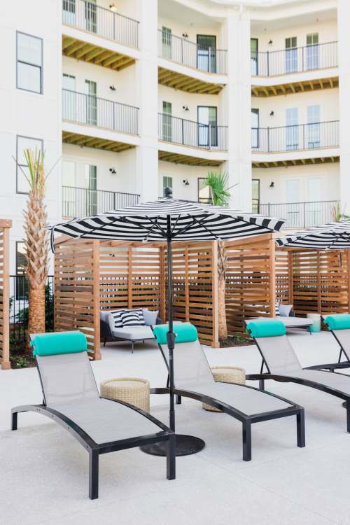 Lounge chairs lined up by the pool at Proximity Carolina Beach in Carolina Beach, North Carolina