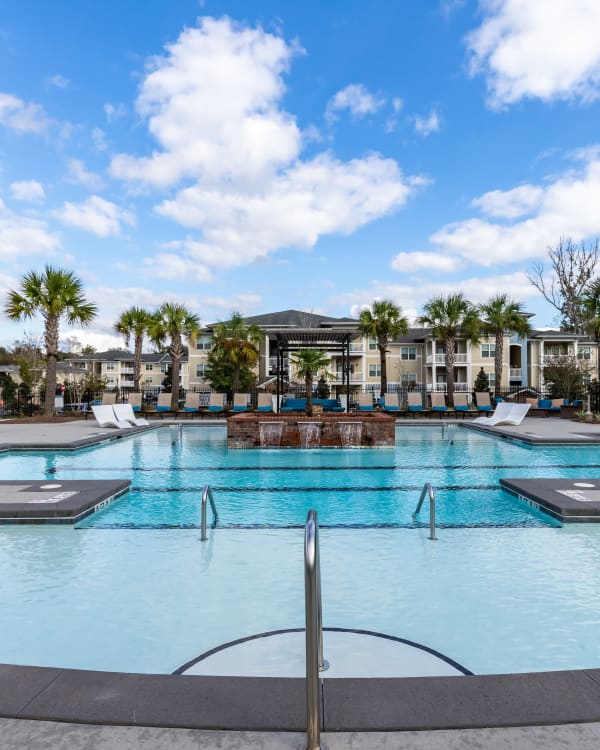 Swimming pool with an island of vegetation at Ansley Commons Apartment Homes in Ladson, South Carolina