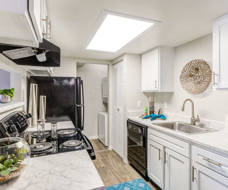 Kitchen with sleek black appliances and granite-style countertops in a model home at Santana Ridge in Denver, Colorado