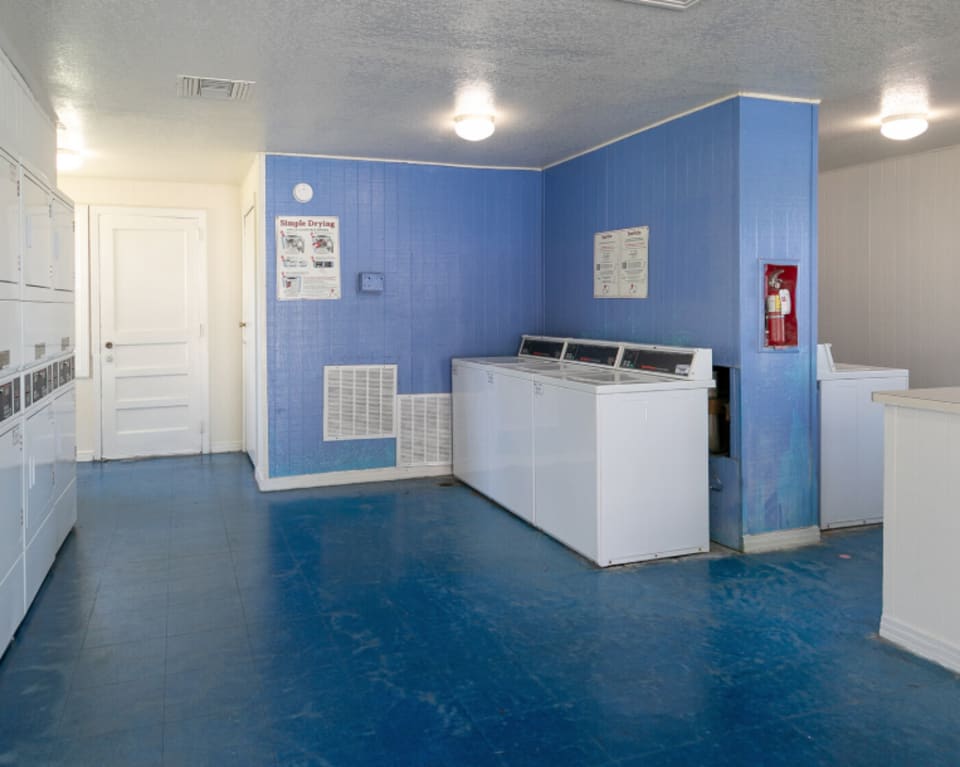 Laundry Room Interior With Blue Walls And White Appliances at St. Johns Landing Apartments in Green Cove Springs, Florida