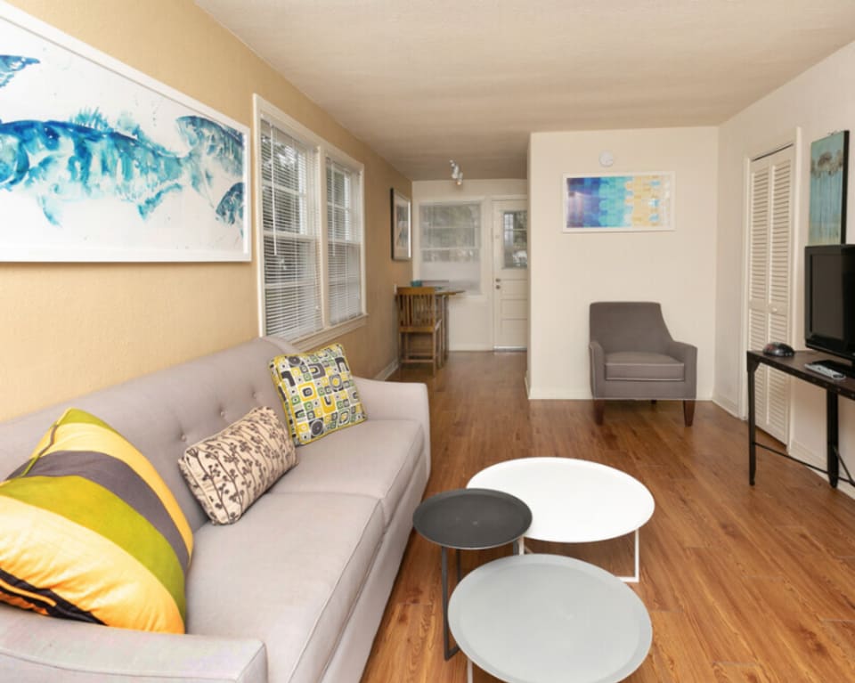 Apartment Living Room With Couch And Artwork at St. Johns Landing Apartments in Green Cove Springs, Florida