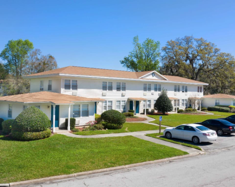 Exterior View Of Apartment Building With Parking Spaces at St. Johns Landing Apartments in Green Cove Springs, Florida