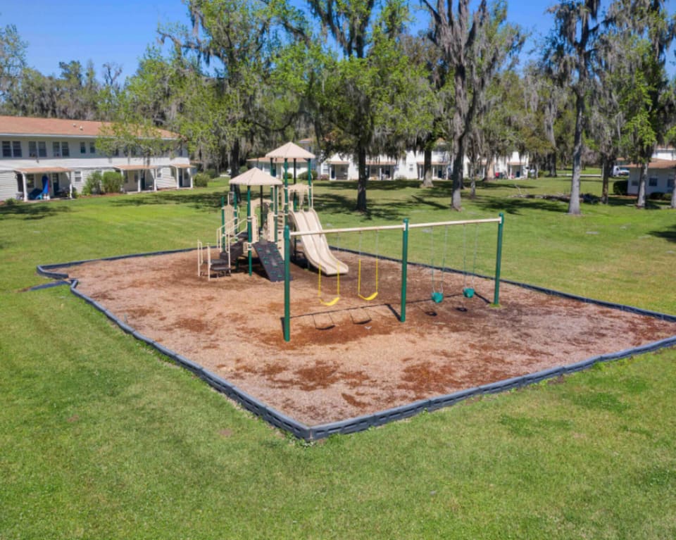 Apartment Complex Playground With Swings And Slide at St. Johns Landing Apartments in Green Cove Springs, Florida