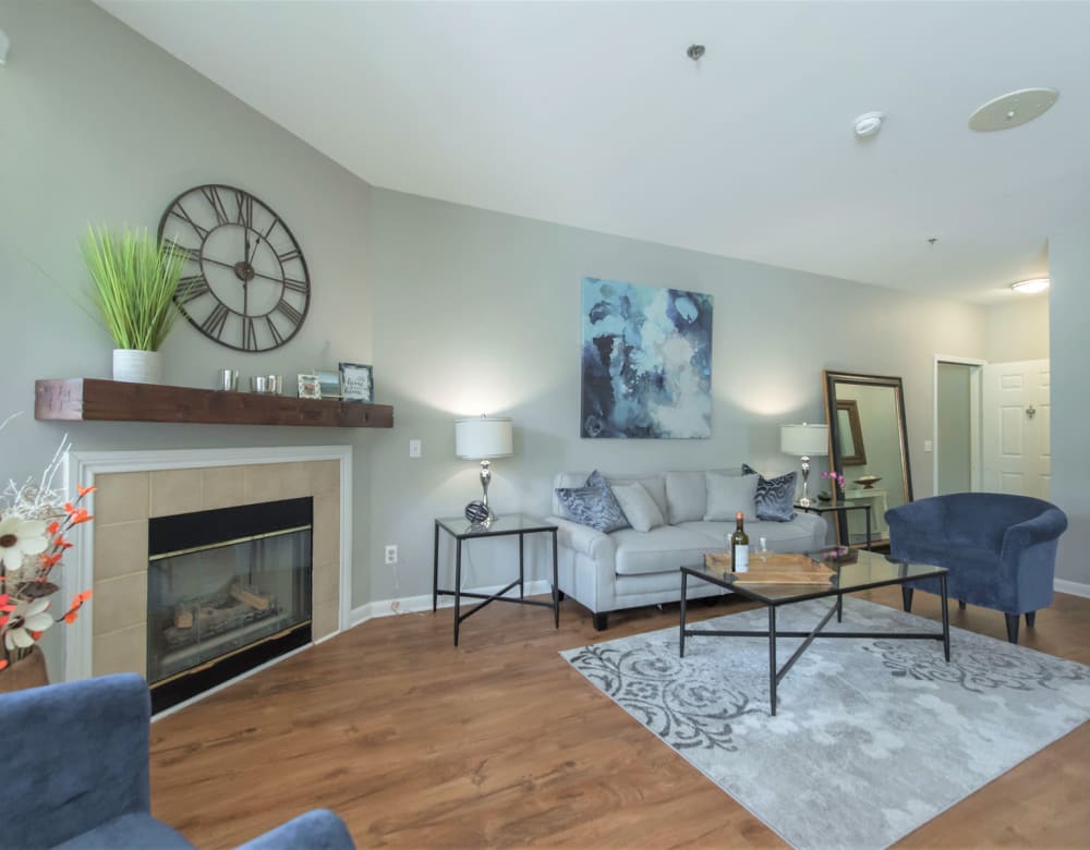 Living area with a fireplace and hardwood-style flooring in a model home at Eagle Rock Apartments at Fishkill in Fishkill, New York