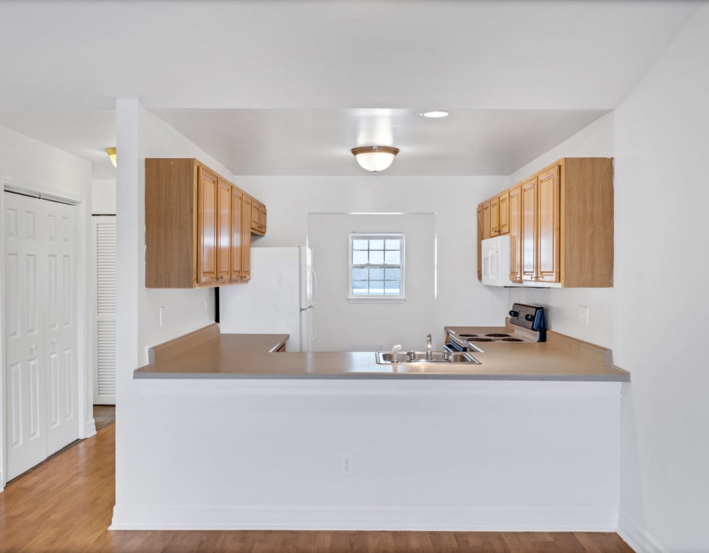 Modern kitchen with expansive granite-style countertops in a model home at Eagle Rock Apartments & Townhomes at Rensselaer in Rensselaer, New York