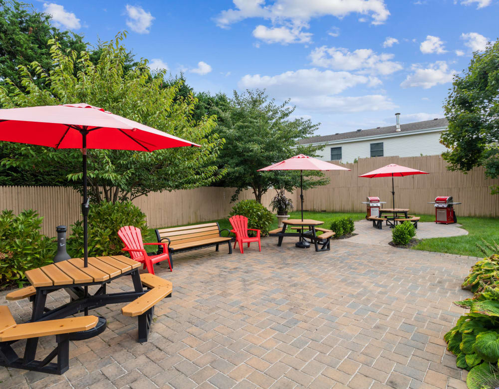 Outdoor grill area with table and benches at Seaford Gardens in Seaford, New York