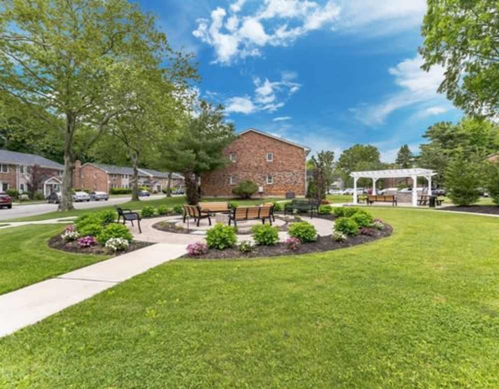 Outdoor seating area in a well-trimmed lawn at Eagle Rock Apartments at Woodbury in Woodbury, NY