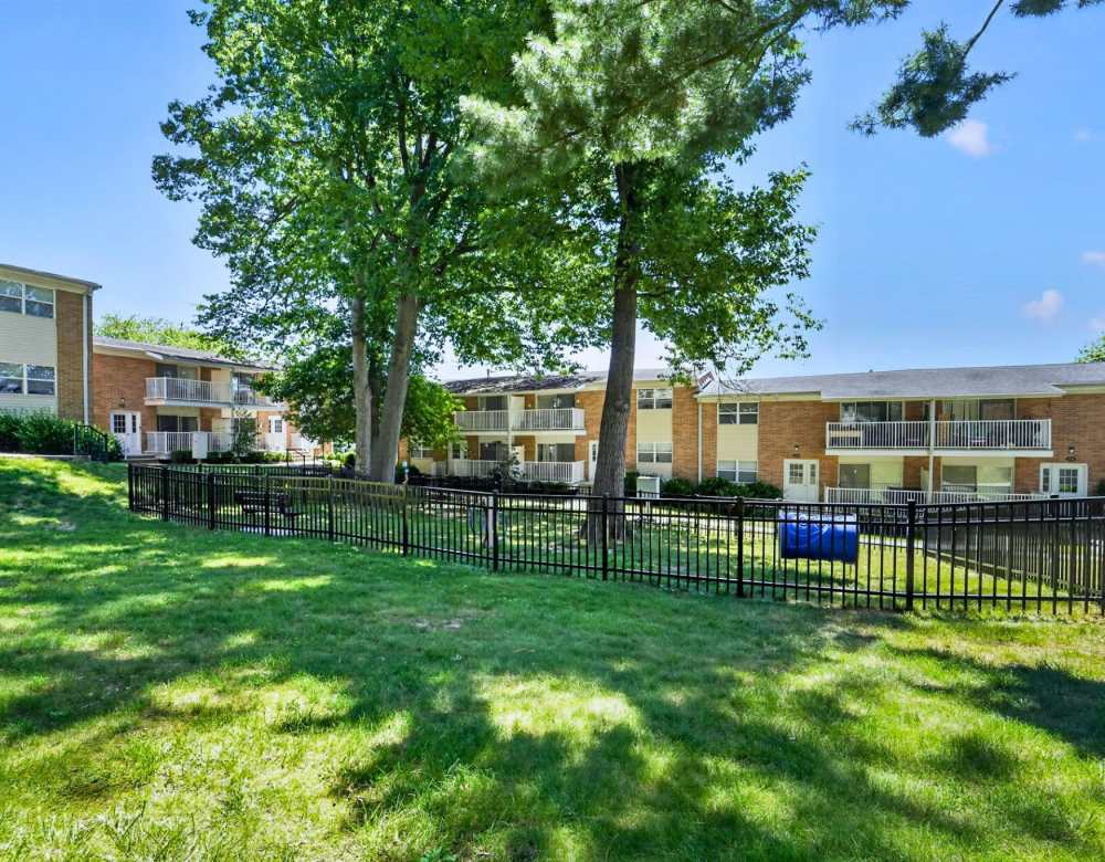 Apartment community lawn with large trees and fenced courtyard at Eagle Rock Apartments at North Plainfield in North Plainfield, New Jersey                                             