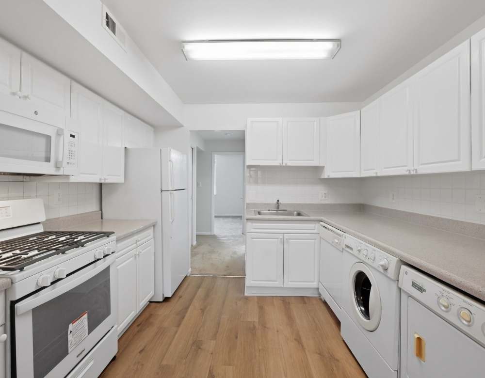 Bright kitchen with white cabinets and appliances at Fairway Apartments in Reston, Virginia