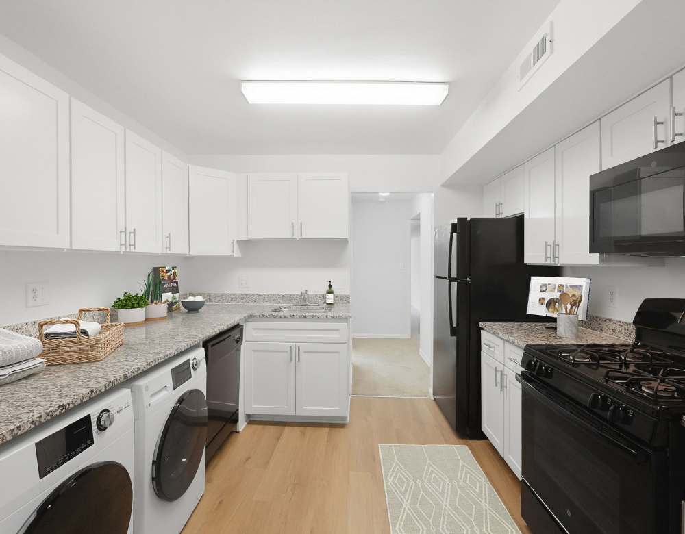 Bright kitchen with white cabinets and appliances at Fairway Apartments in Reston, Virginia