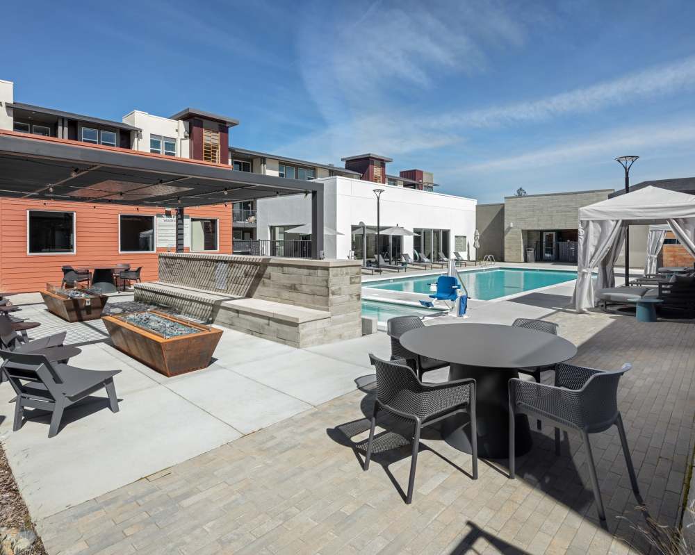 Outdoor pool with many tables and chairs at SoCo Apartments in Napa, California