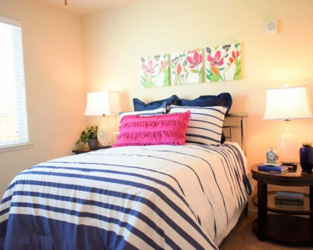 Beautiful bedroom with stripe sheets, pillows and painting at Vines on 80 in Fairfield, California