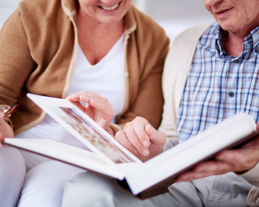 Seniors looking at a photo album at Welbrook Grand Montecito in Las Vegas, Nevada