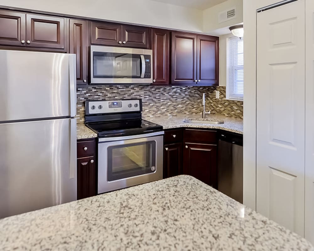 Kitchen with granite countertops and stainless-steel appliances at Moorestowne Woods Apartment Homes in Moorestown, New Jersey