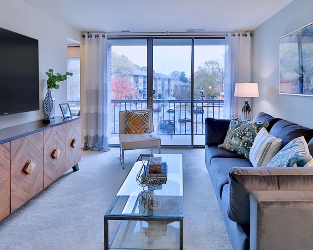 Spacious living room opening onto a private balcony at Chesapeake Glen Apartment Homes in Glen Burnie, Maryland