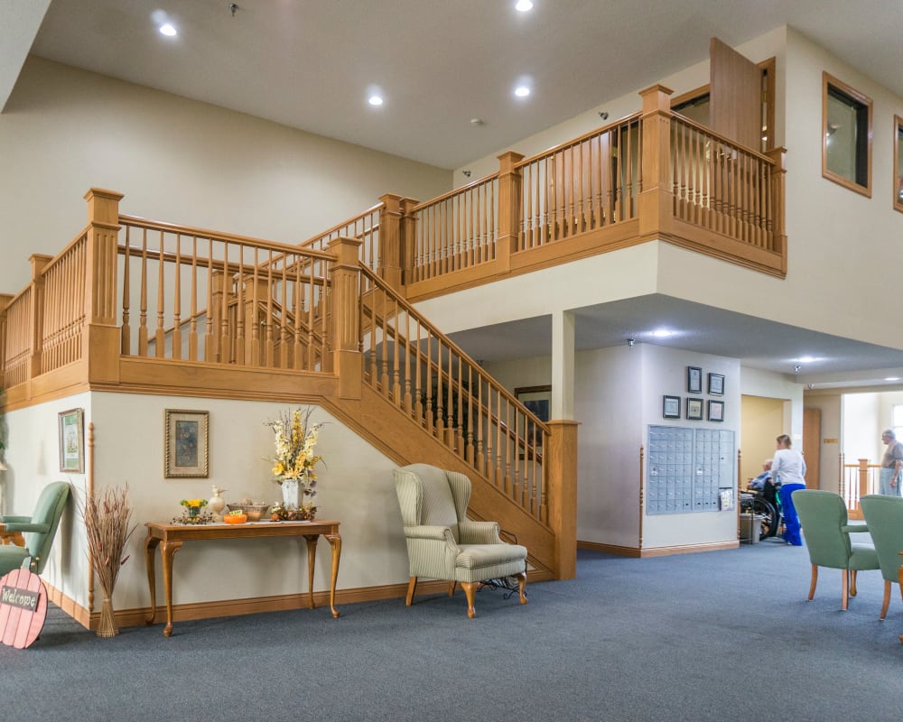 Spacious main entrance with elaborate staircase at Prairie Meadows Senior Living in Kasson, Minnesota.