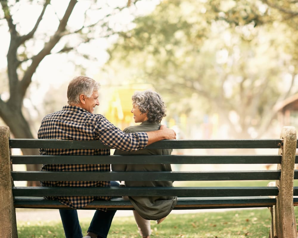 Resident couple sitting on a bench outside Whispering Oak Place in Ellendale, Minnesota.