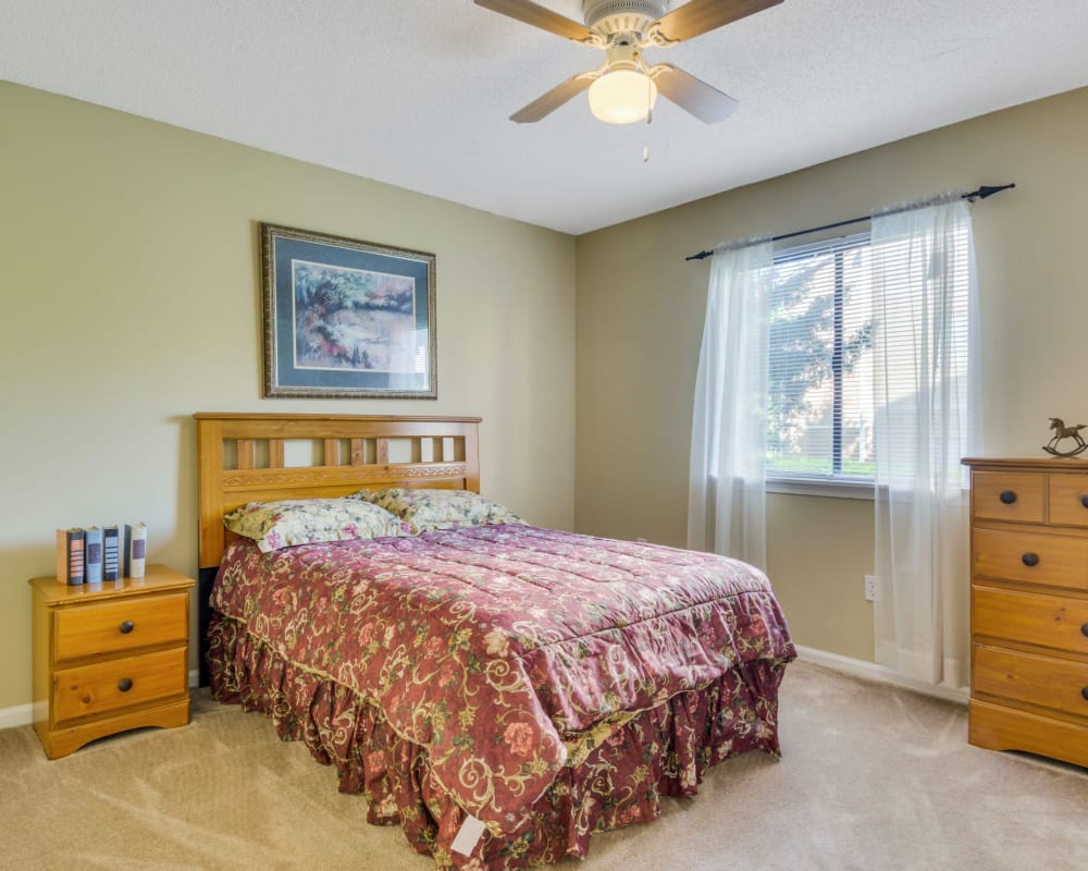 Spacious bedroom with a large window and plush carpeting at Woodbrook Apartment Homes in Monroe, North Carolina