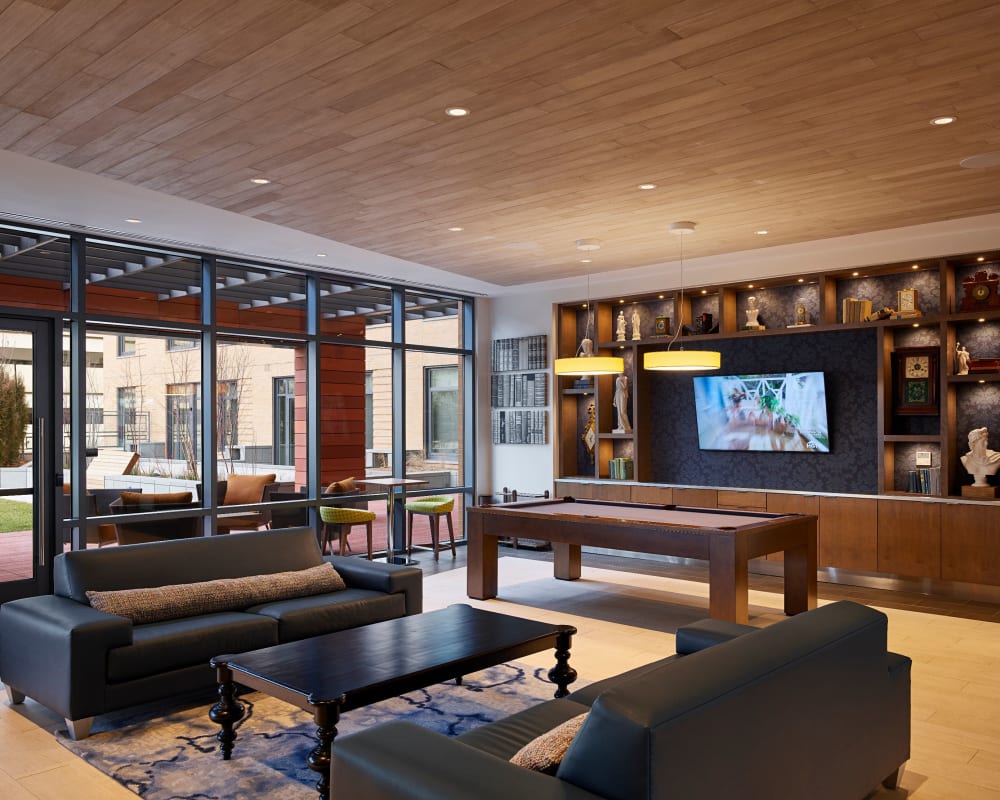 Rustic clubhouse with bar seating, flat-screen TVs and a fireplace at Solaire 8250 Georgia in Silver Spring, Maryland