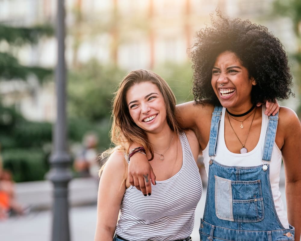 Two friends holding each other with smiles on their faces near The View on Pavey Square in Columbus, Ohio