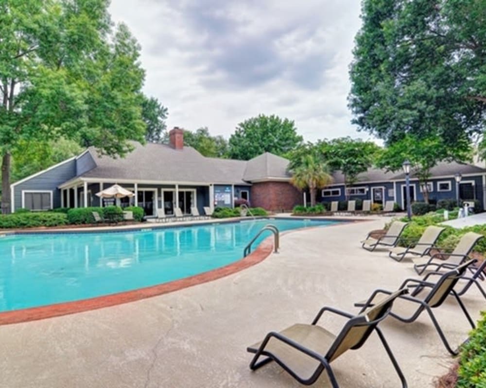 Resort-inspired swimming pool with plenty of poolside lounge chairs at St. Andrews Commons Apartment Homes in Columbia, South Carolina